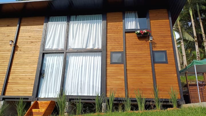 Fachada em madeira da cabana com amplas janelas